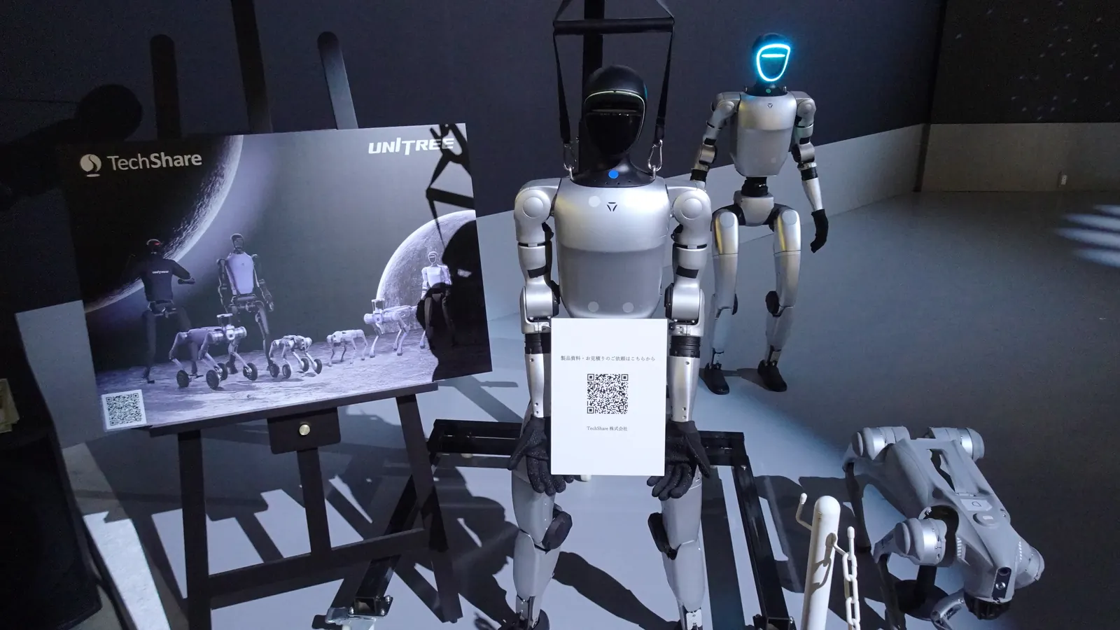 Unitree G1 and Go2 robots on a trade show stand (Japan Mobility Show 2025)